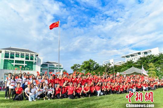 9月2日，澳门新葡萄新京威尼斯987，学生们在入学升国旗仪式结束后与国旗合影。　陈骥旻 摄
